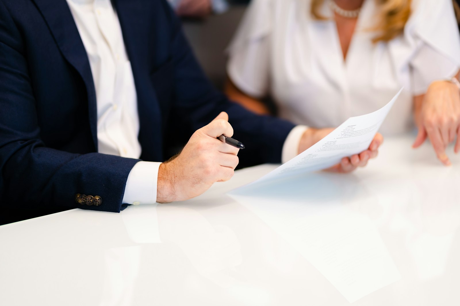 Advogado e cliente analisando um documento sobre a mesa